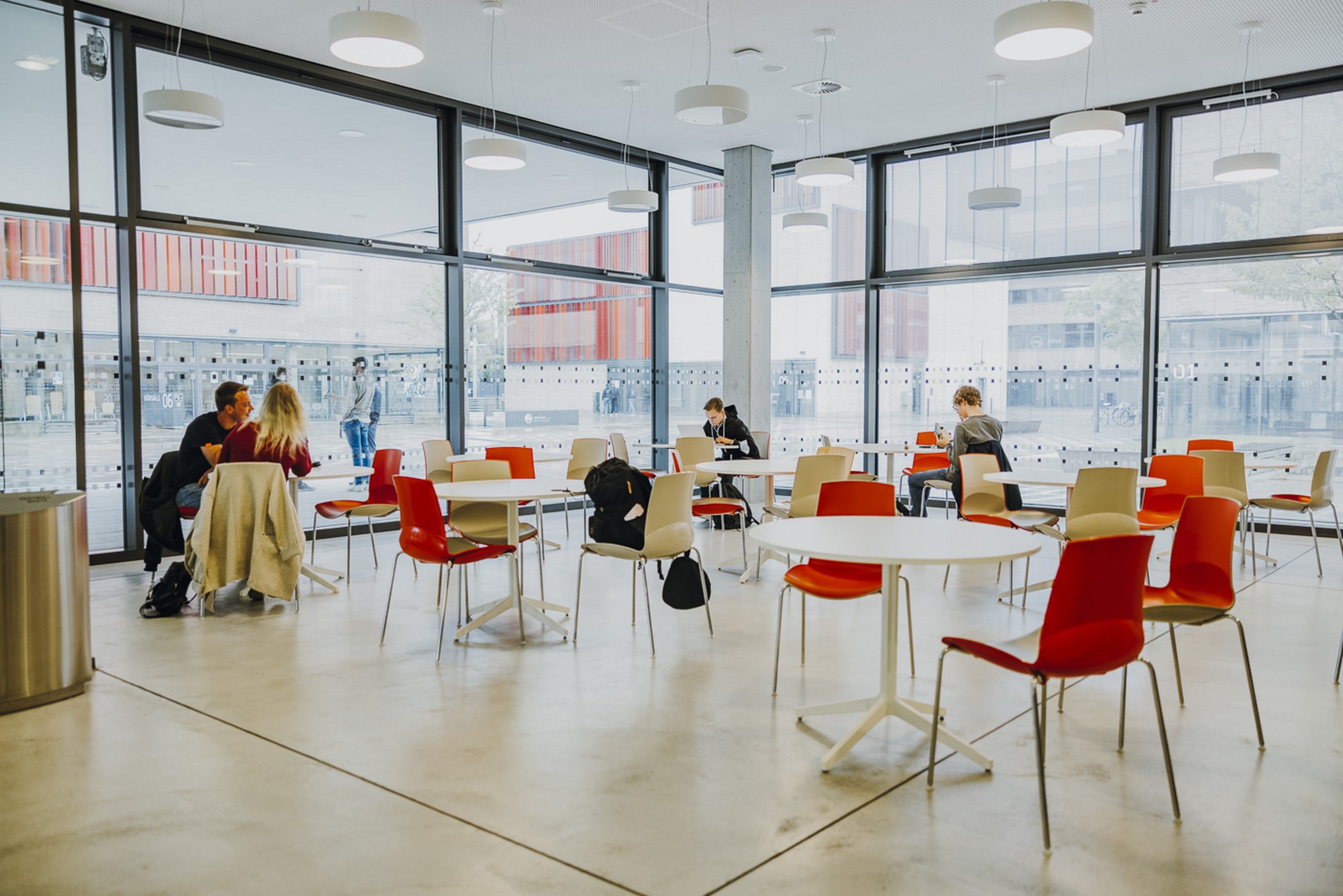 Studierende sitzen in der Cafeteria.