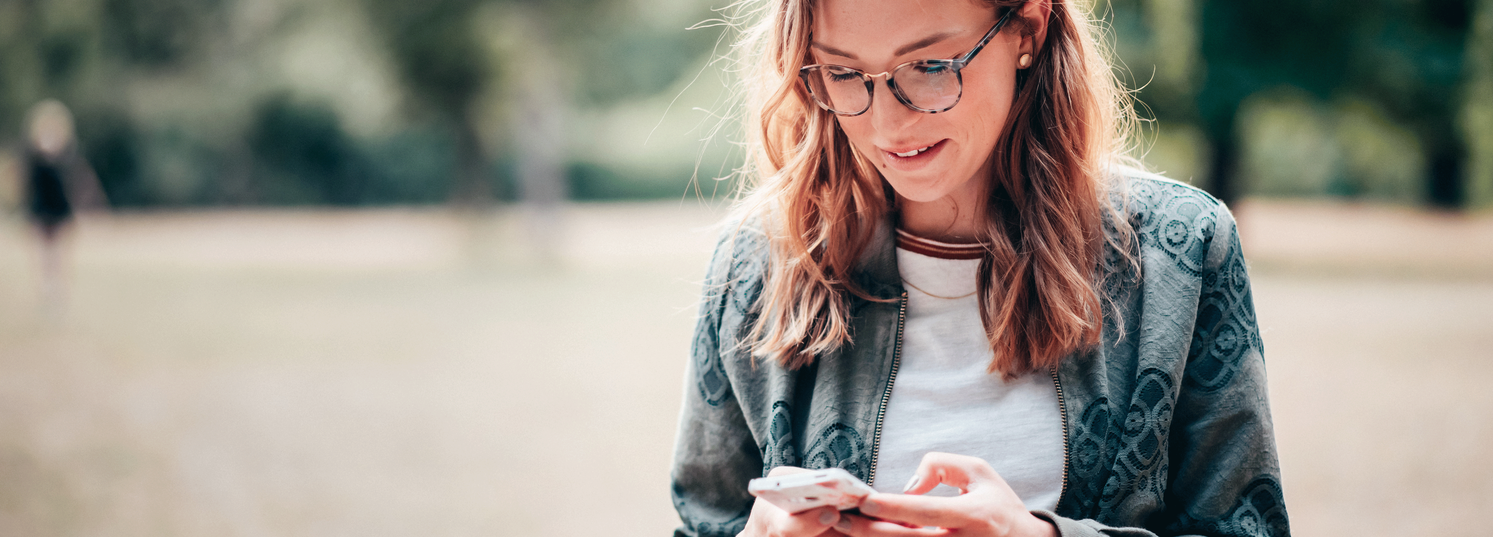 Eine Studentin schaut auf ihr Smartphone. 